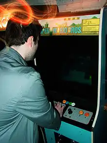 Homme jouant sur une borne d'arcade