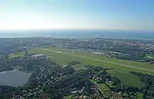 Photographie en couleurs représentant l'aéroport vu du ciel.