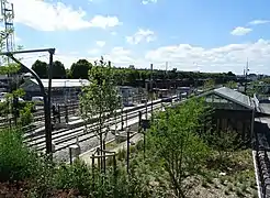 Vue d'ensemble de la gare avec les voies du T11 Express, de la Grande Ceinture et les deux bâtiments voyageurs.