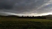 Vue des lignes de fortifications reconstituées au MuséoParc Alésia par ciel de tempête