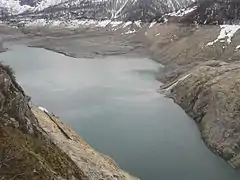 Vue générale du lac du Chevril vide avec les restes de l'ancien village de Tignes au fond.