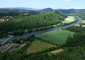 Vue Nord-Est depuis le belvédère de la chapelle Notre-Dame du Mont: tour/donjon médiéval de Montferrand-le-Château surplombant les méandres du Doubs.