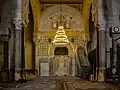 Vue du mihrab dans son environnement. La niche en cul-de-four, dotée d'un fond polyédrique, est soigneusement ornée. Elle est située approximativement au milieu du mur de la qibla de la salle de prière.