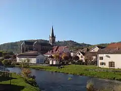 Groupe de bâtiments dont une église traversé par une rivière.