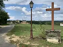  Photo avec une église en fond avec au premier plan une croix et un lampadaire