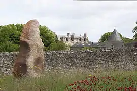 Menhir-polissoir de la Grouas devant le château des Noyers.