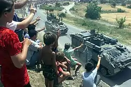 Warrior et Stormer HMV des Irish Guards sont acclamés alors qu'ils passent devant des réfugies du camp de Brazda, à la frontière Macédonienne du Kosovo, alors qu'ils avancent vers Pristina.