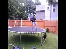 Deux personnes sur un trampoline effectuant une souplesse.