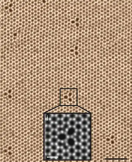 Vue au microscope électronique en transmission à balayage (STEM) d'une monocouche de diséléniure de tungstène à 500 °C montrant sa structure hexagonale avec ses défauts trifoliés.