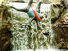 Statue du capitaine mise en scène dans une attraction, dans laquelle il apparaît suspendu à une corde devant une chute d'eau.