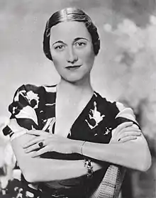 Photographie en noir et blanc du buste d'une femme vue de face, les bras croisés sur la poitrine.
