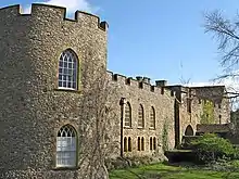 L'extérieur d'un château aux murs crénelés.