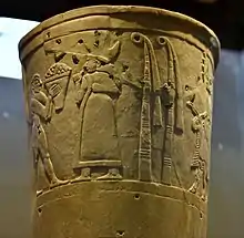 Personnage féminin, généralement interprété comme étant la déesse Inanna recevant des offrandes, registre supérieur du vase d'Uruk. Musée national d'Irak.