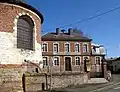 La mairie et le chevet de l'église, en grès, pierre et brique.