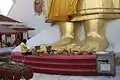 Une femme prie sur les pieds de Bouddha.