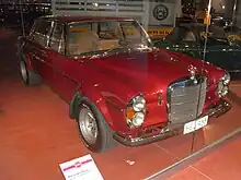 Photo d'une voiture de course de couleur rouge dans une vitrine.