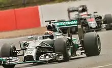 Photo de la Mercedes AMG F1 W05 de Wehrlein suivie par la McLaren MP4-31 de Vandoorne à Silverstone