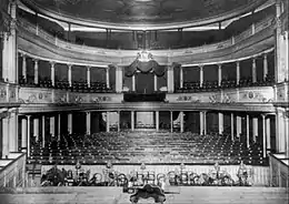 Photographie en noir et blanc de l'intérieur d'une salle de concert vide.