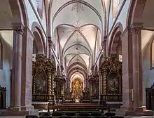 Photographie couleur de la nef et du chœur d'une église gothique.