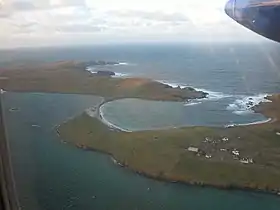 Vue aérienne du Sud de Burra Ouest montrant la péninsule rattachée au reste de l'île par un isthme, la baie de Banna Minn et le hameau de Duncansclett.