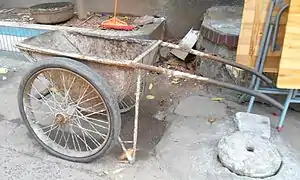 Brouette à deux roues chinoise, centrée sous la caisse pour éliminer le port du poids.