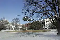 Marine One décollant de la pelouse Sud. On aperçoit à gauche la colonnade et l'aile Ouest et en arrière-plan le Old Executive Office Building