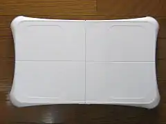 Photographie de la Wii Balance Board, une balance blanche en plastique.