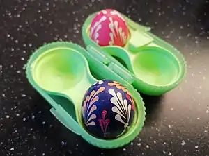 Boîte à œufs durs de la marque Tupperware, avec des œufs de Pâques décorés