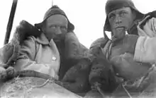 Photographie en noir et blanc de deux hommes emmitouflés dans leurs vêtements chauds.
