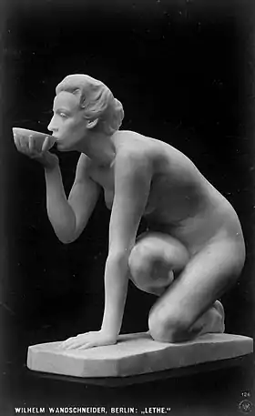 Statue d'une femme ayant posé une main et un genou au sol, et qui boit à un bol dans son autre main