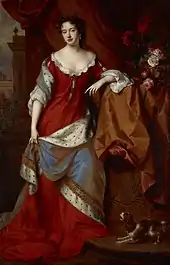 Portrait d'une jeune fille debout vêtue d'une robe rouge doublée d'hermine
