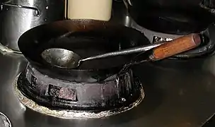 Wok en acier au carbone sur un poêle wok chinois.