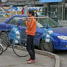 Femme portant des lapins en cage.