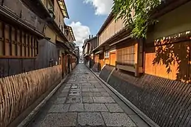 Façades en bois et en bambou d'habitations avec des sudare dans la rue piétonne, pavée et pittoresque du pont Gion tatsumi, effet de perspective avec un point de fuite central, Gion (juin 2019).