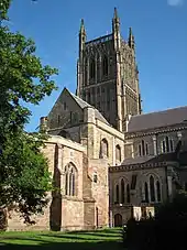 Une partie du bâtiment d'une cathédrale apparaît derrière un arbre.