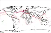 Carte du monde simplifiée sur lequel figure le réseau de fibre optique mondial (2007), représenté par des fils rouges.