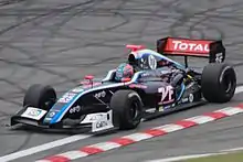 Photographie d'une monoplace de Formule Renault 3.5 noire, vue de trois-quarts, dans son ensemble.