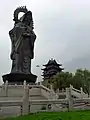 Statue de Guanyin et grande tour en bois à l'arrière du temple.