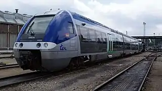 Automotrice tri caisse bleu et gris dans un dépôt.