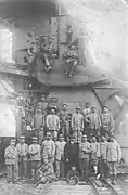 Photo ancienne en noir et blanc d'une équipe d'ouvriers devant une excavatrice.