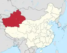 Carte de la Chine (en jaune), des pays voisins (en gris) et du Xinjiang (en rouge, en haut et à gauche). Une étendue d'eau, à droite.