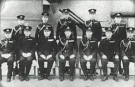 Photographie en noir et blanc d'officiers japonais. Les sept officiers du premier plan sont assis et les cinq à l'arrière plan sont debout.