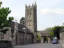 Une église de pierre grise au clocher rectangulaire.