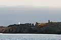 Au loin le grand phare de l'île d'Yeu (de couleur blanche) et, au centre sur la côte rocheuse, le Vieux Château.