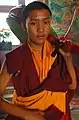 Le jeune batteur tibétain avec son tambour sur l'épaule se prépare à jouer le jour du Bodhisattva!