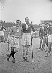 Photographie en noir et blanc de deux hommes debout prenant la pose côte à côte.