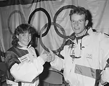 Photo d'Yvonne van Gennip et Leo Visser devant un drapeau olympique