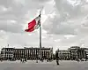 Panorama de la place de la Constitution à Mexico, terminus du Camino Real ; un drapeau mexicain monumental flotte au centre de la photographie.