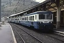 Photo couleur d'une automotrice en livrée bleu, blanc et gris à quai en gare.