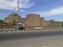 route bitumée devant le chateau en pierre